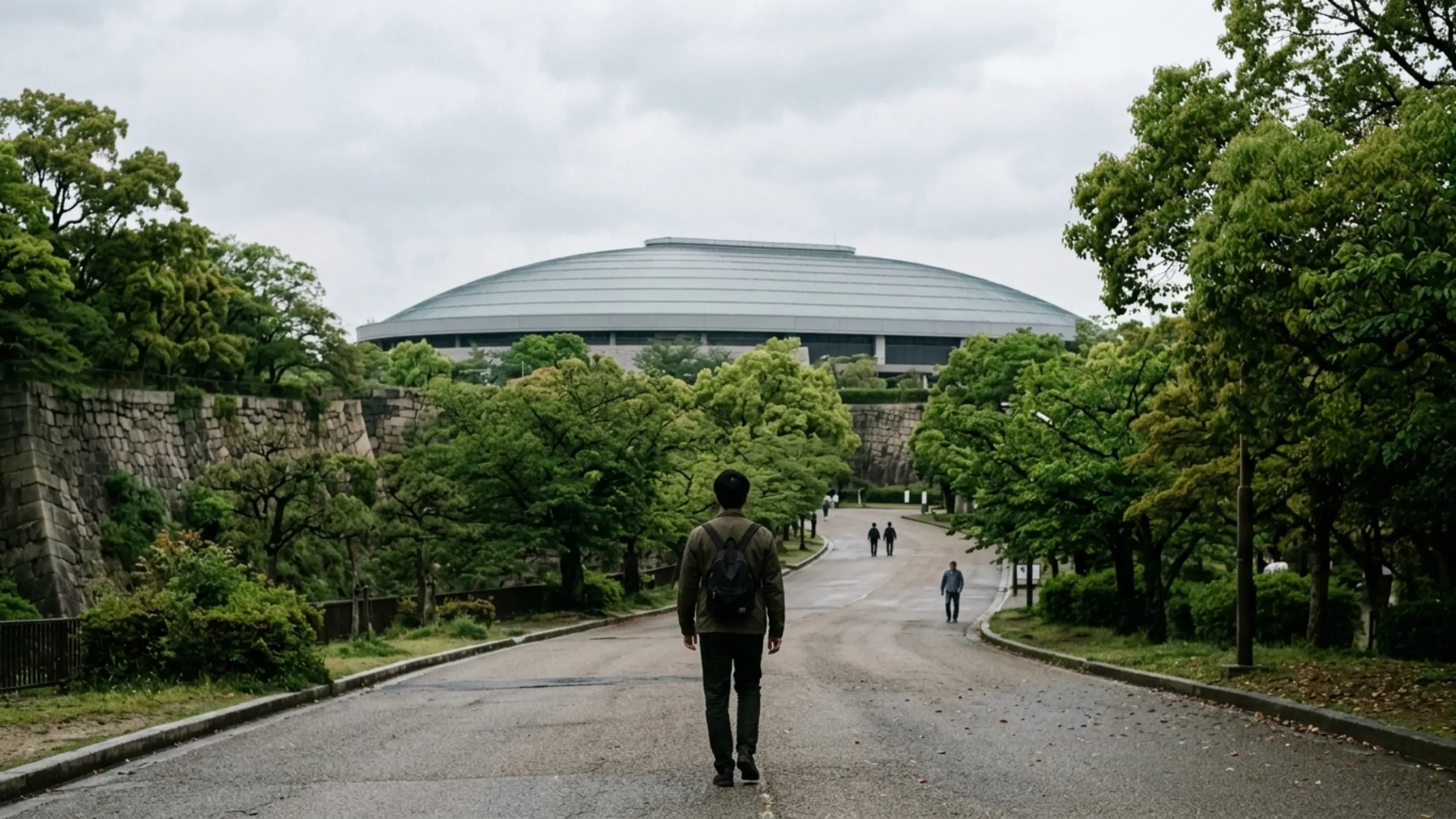 大阪城公園の緑あふれる道を大阪城ホールへ向かう人の後ろ姿